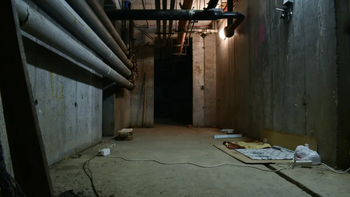 basement mold growing risk inside a dark damp concrete basement tunnel