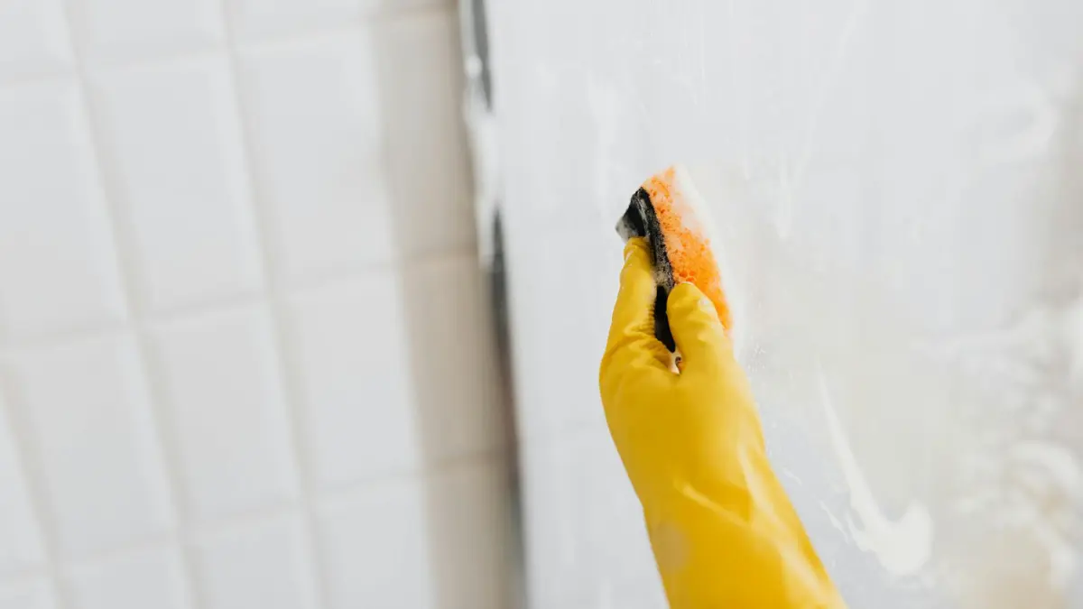 black mold removal step by step yellow rubber gloves cleaning bathroom shower glass surface with sponge and detergent
