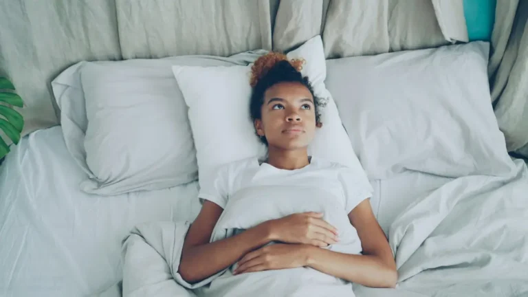 Black Mold Symptoms - Woman feeling sick and unwell while resting in bed at home