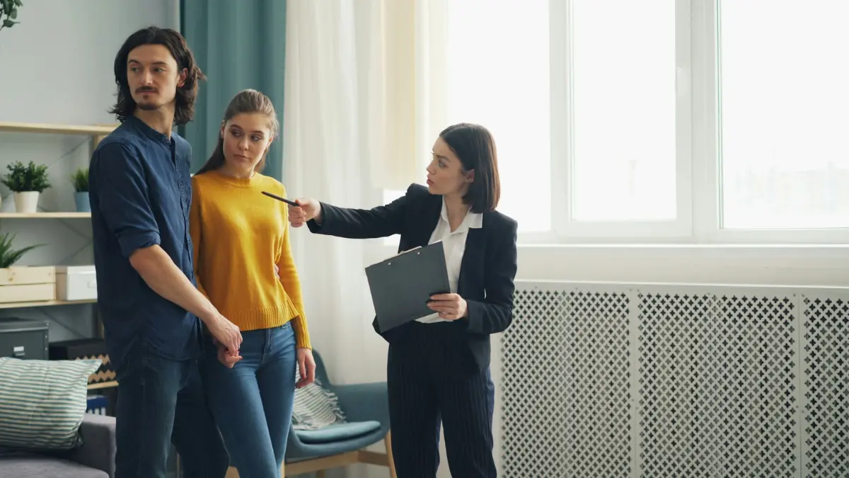 Housing inspector with clipboard pointing at an apartment wall while tenants observe, illustrating official verification steps in tenant rights cases.