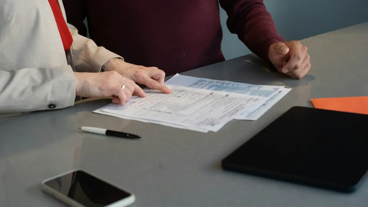 Two people reviewing documents at a table, demonstrating the written paper trail tenants need to build to protect their tenant rights in mold disputes.