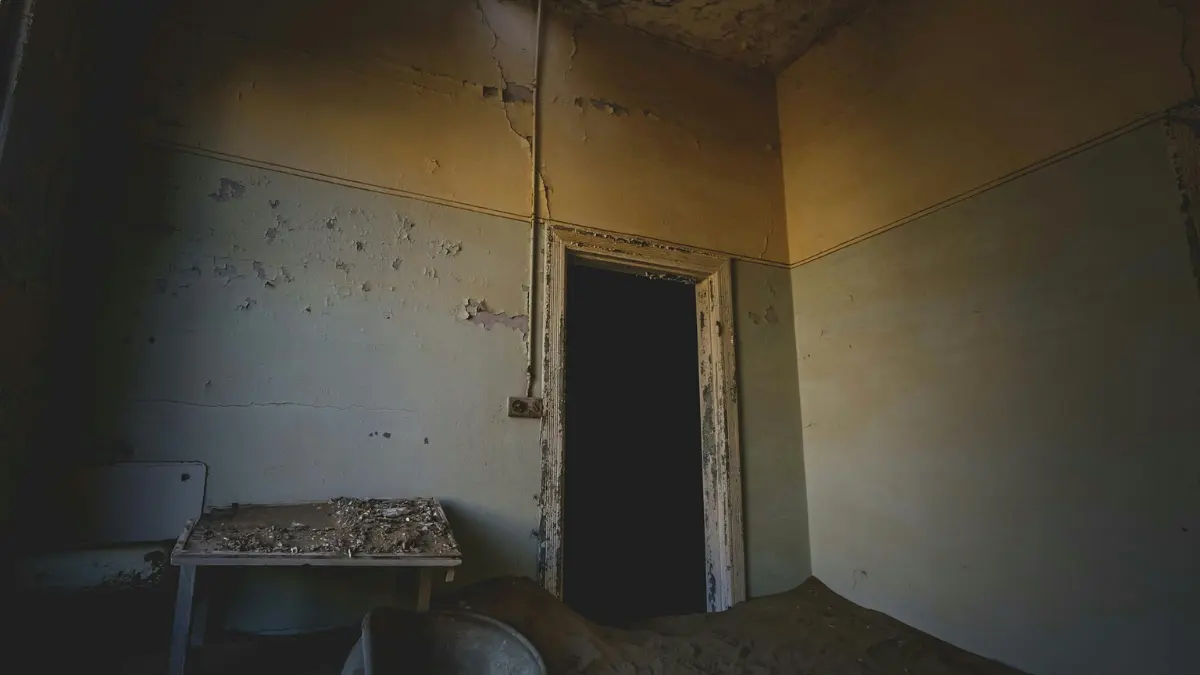 Mold remediation before selling — bedroom with visible mold damage on walls and ceiling in a furnished home being prepared for sale.