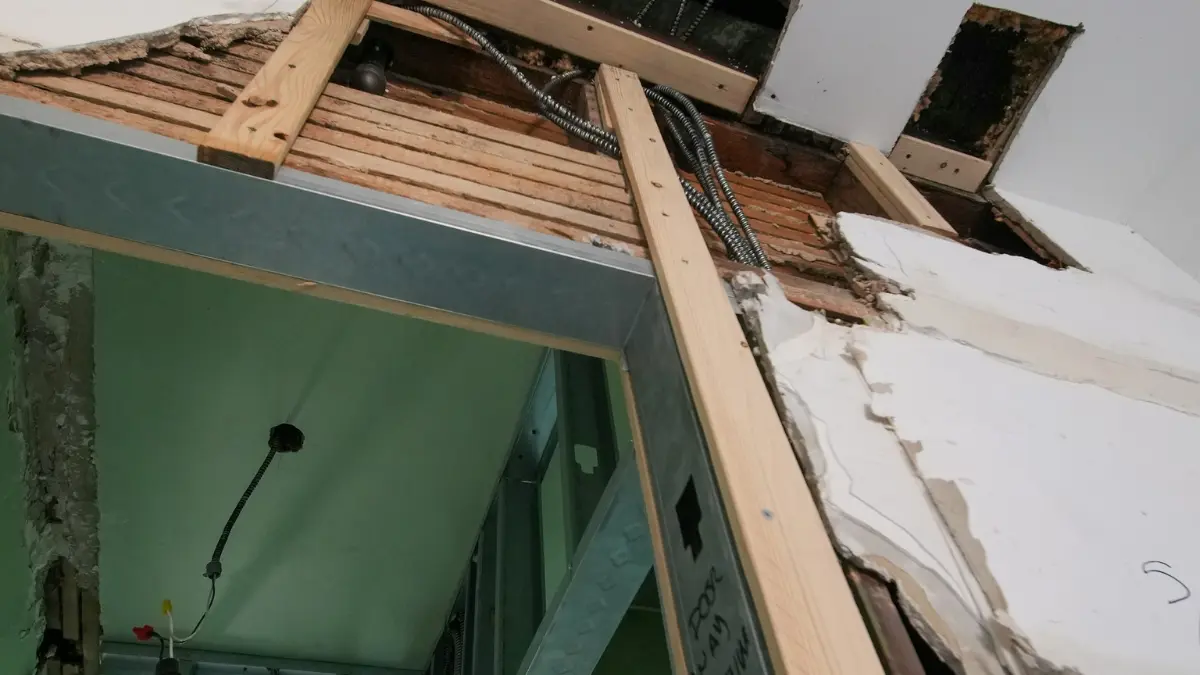 Mold remediation before selling — ceiling and wall demolition exposing wood framing, wiring, and structural repairs during professional mold cleanup.