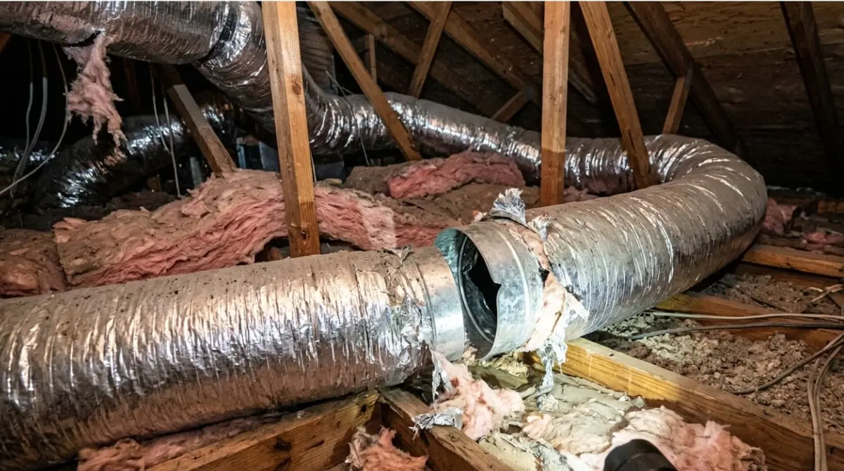 Ducted HVAC system with a loose duct connection leaking air in an attic
